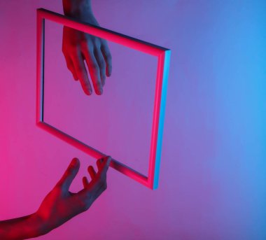 Yaratıcı sanat. Süzülen bir çerçeveden süzülen kadın elleri ve neon holografik ışık. Kıvılcım. Pop sanat. 80 'ler