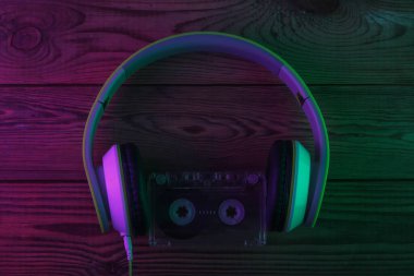 Retro stereo kulaklıklar ve ses kaseti. Neon mor ışık. Kıvılcım. 80 'ler. Üst görünüm