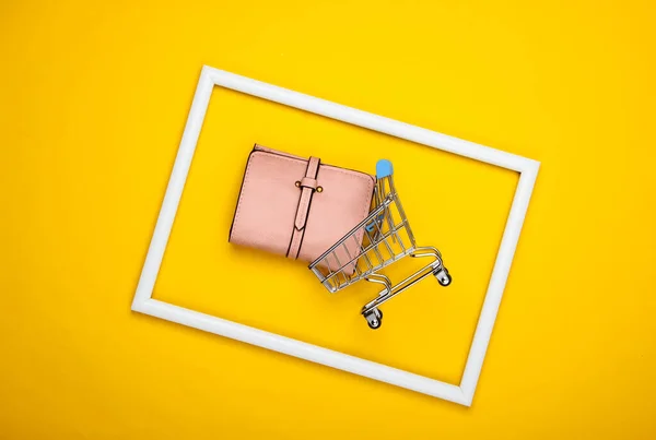 Carrinho Compras Com Carteira Couro Uma Moldura Branca Fundo Amarelo — Fotografia de Stock