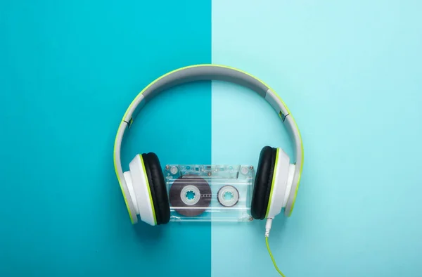 青の背景にオーディオカセットとスタイリッシュな有線ステレオヘッドフォン 音楽好き 80年代レトロ トップ表示 — ストック写真