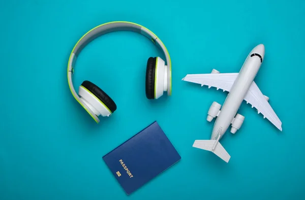 Concepto Viaje Auriculares Estatuilla Avión Pasaporte Sobre Fondo Azul Viaje — Foto de Stock