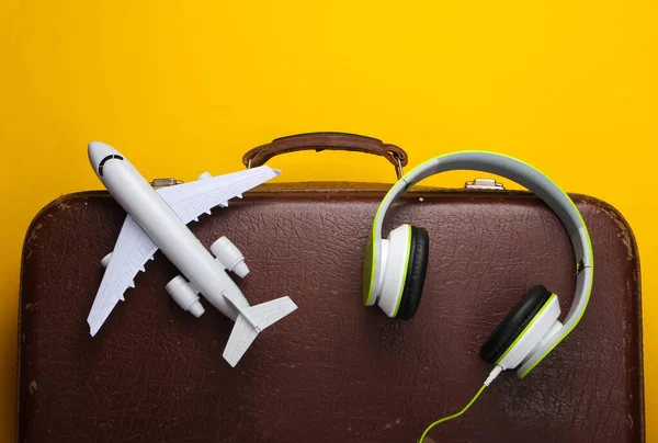 Concepto Viaje Equipaje Antiguo Auriculares Estatuilla Avión Sobre Fondo Amarillo — Foto de Stock