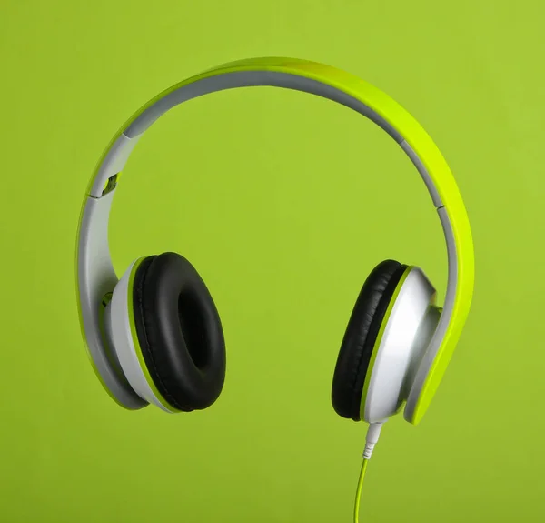 緑の背景に現代の有線ステレオヘッドフォン — ストック写真