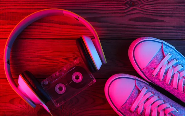 Stereo Kopfhörer Mit Audiokassette Und Turnschuhen Auf Holzgrund Neonrotes Blaues — Stockfoto