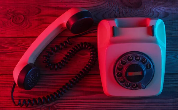 Retro Rotační Telefon Dřevěném Pozadí Červenomodrým Neonovým Světlem Pohled Shora — Stock fotografie