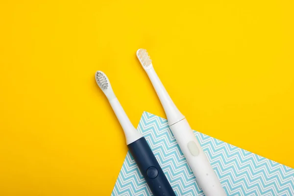 Two Modern Electric Toothbrushes Yellow Background Top View Teeth Care — Stock Photo, Image