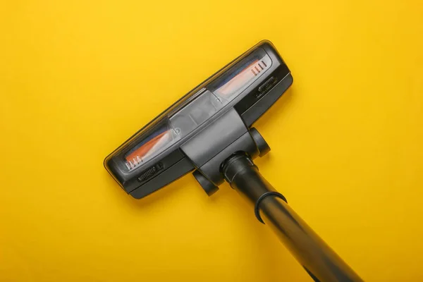 Vacuum cleaner brush on yellow background. Top view. Cleaning concept.