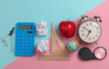 Okula dönelim. Okul ve ofis malzemeleri mavi pembe pastel arka planda. Eğitici, öğrenim konsepti. Üst görünüm.