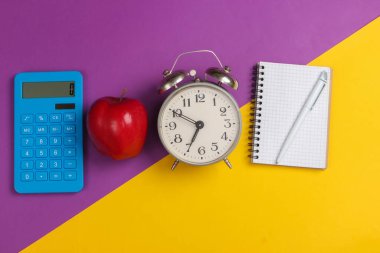 Okula dönelim. Okul ve ofis malzemeleri mor sarı arka planda. Eğitici, öğrenim konsepti. Üst görünüm.