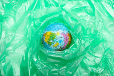 Kirlilik. Plastiksiz. Eko konsepti. Naylon bir torbaya sarılı bir dünya. Gezegeni kurtar. Minimalizm