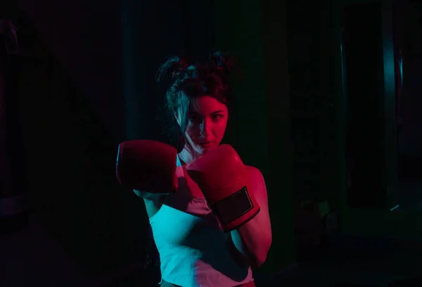 若いです女性ボクサーでボクシング手袋でネオングラデーションピンク青光で暗い背景 — ストック写真