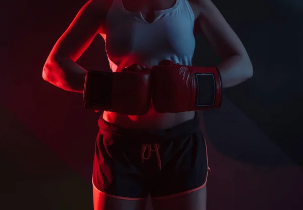 女性ボクサーとともにボクシング手袋で彼女の手でネオン青赤光上の暗い背景 — ストック写真