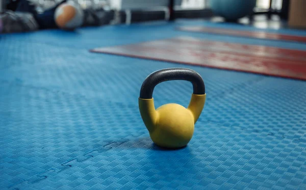 Kettlebell on the floor with blue rubber coating in the gym