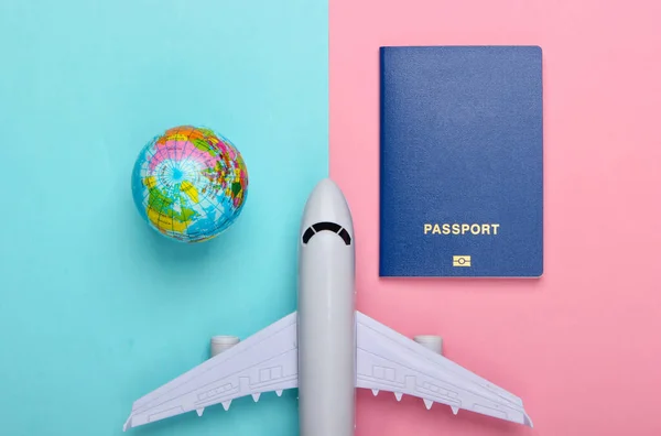 Toerisme Reisconcept Emigratie Globe Paspoort Passagiersvliegtuig Beeldje Roze Blauwe Pastelachtergrond — Stockfoto