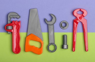 Yeşil mor pastel arka planda plastik çocuk çalışma çantası. Oyuncaklar. Üst görünüm