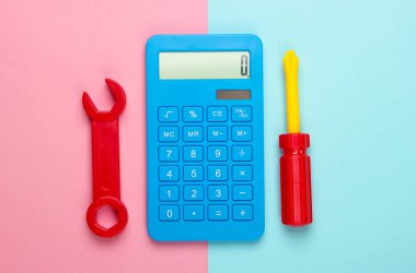 Tamir maliyetinin hesaplanması. Hesap makinesi, oyuncak anahtar ve pembe mavi arka planda tornavida. Üst görünüm