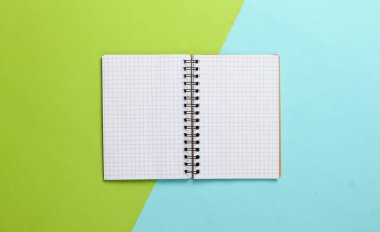 Mavi-yeşil pastel arka planda not defteri. Üst Manzara. Planlama veya eğitim kavramı.