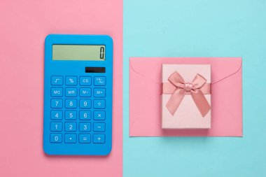 Üzerinde pembe-mavi pastel arka planda zarf ve hediye kutusu olan bir hesap makinesi. Üst görünüm