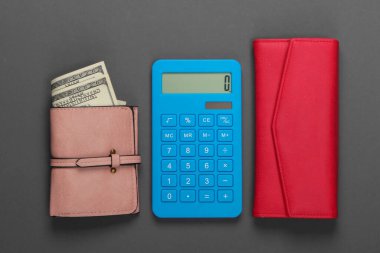 Aile bütçesini yönet. Alışveriş maliyetleri. Gri arka planda deri cüzdanları olan mavi hesap makinesi. Üst görünüm