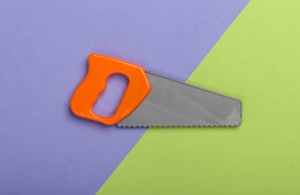 Toy Mini Plastic Saw Green Purple Background Top View — Stock Photo, Image