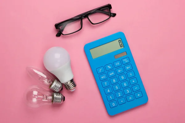 Energiesparen Taschenrechner Mit Glühbirnen Brille Auf Rosa Blauem Hintergrund Ansicht — Stockfoto