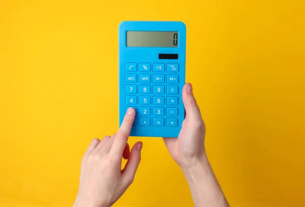 Ręcznie Trzyma Niebieski Kalkulator Żółtym Tle — Zdjęcie stockowe