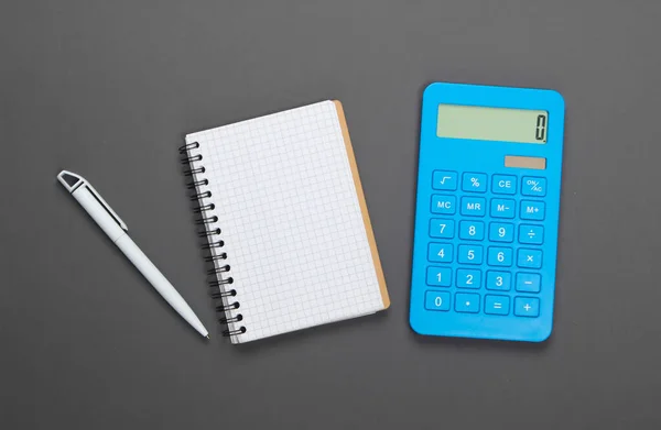 Calculator Met Een Notitieboekje Een Grijze Achtergrond Gezinsbudgetbeheer Bovenaanzicht — Stockfoto