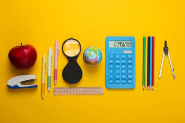 Okula dönelim. Sarı arka planda okul ve ofis malzemeleri var. Eğitici, öğrenim konsepti. Üst görünüm.