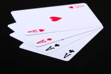 Siyah arka planda dört as oynuyorum. Oyun bağımlılığı. Poker