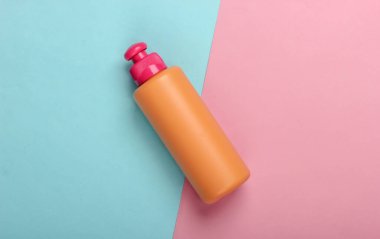 Mavi pembe arka planda şampuan şişesi. Saç bakımı. Hijyen ve kozmetik. Güzellik düzlüğü. Üst görünüm