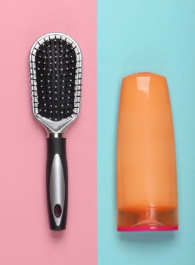 Mavi pastel arka planda şampuan şişeli saç fırçası. Saç bakımı. Hijyen. Güzellik düzlüğü. Üst görünüm