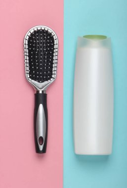 Mavi pastel arka planda şampuan şişeli saç fırçası. Saç bakımı. Hijyen. Güzellik düzlüğü. Üst görünüm