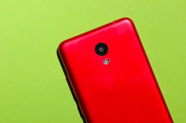 Yeşil arka planda kırmızı akıllı telefon. Üst görünüm