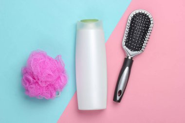 Banyo, pembe mavi arka planda güzellik ürünleri. Şampuan, saç fırçası, sünger. Üst Manzara. Düz yatıyordu