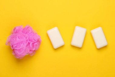 Banyo, sarı arka planda güzellik ürünleri. Sünger ve sabun. Üst Manzara. Düz yatıyordu