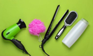 Yeşil arka planda saç bakım ürünleri ve cihazlar. Üst Manzara. Düz yatıyordu