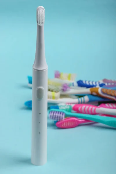 Neue Elektrische Zahnbürste Und Alte Gebrauchte Zahnbürsten Auf Blauem Hintergrund — Stockfoto