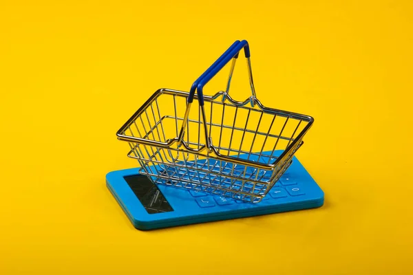 Sarı Arka Planda Hesap Makinesi Alışveriş Sepeti Üst Görünüm — Stok fotoğraf