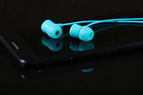 Auriculares Vacío Azules Con Smartphone Sobre Fondo Negro —  Fotos de Stock