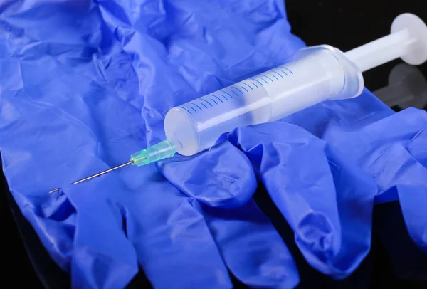黒い背景に注射器付きのクローズアップ医療用ラテックス手袋 予防接種 — ストック写真