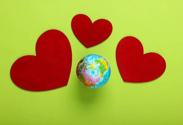 Earth Day. Globe with hearts on a green background.