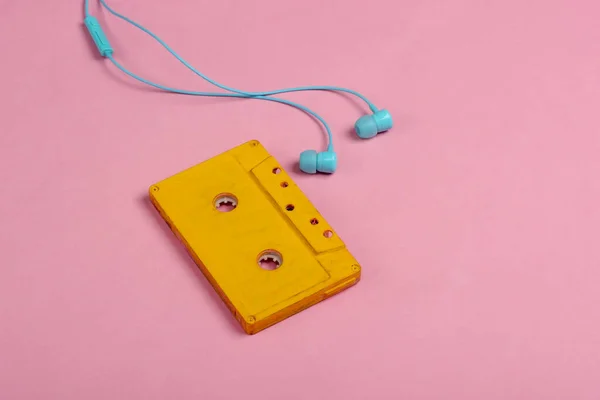 분홍색 파스텔 배경에 이어폰을 오디오 카세트 미나미 — 스톡 사진