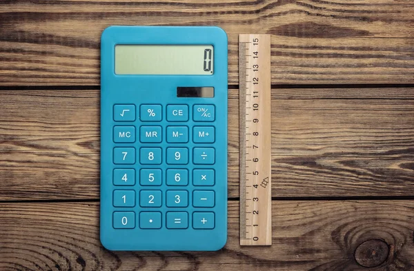 Calculator Met Een Liniaal Een Houten Achtergrond Bovenaanzicht — Stockfoto