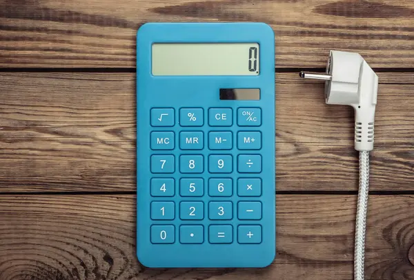 Kalkulator Dengan Colokan Daya Pada Latar Belakang Kayu Penghitungan Biaya — Stok Foto