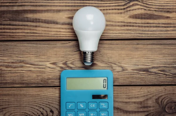 Energiesparkonzept Taschenrechner Mit Glühbirne Auf Einem Hölzernen Hintergrund Ansicht Von — Stockfoto