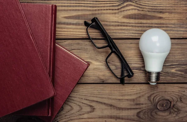 Montón Libros Con Gafas Bombilla Sobre Fondo Madera Vista Superior — Foto de Stock