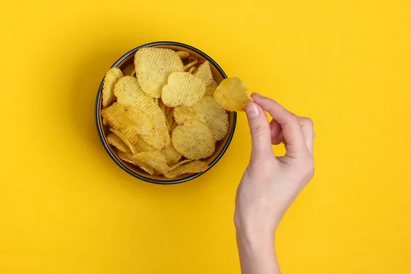 Female Hand Holds Ribbed Potato Chips Bowl Yellow Background — Stock Photo, Image