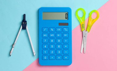 Kırtasiye (okul) makası, hesap makinesi, pembe mavi pastel arka planda pusula. Okul ve ofis malzemeleri. Üst Manzara. Minimalizm