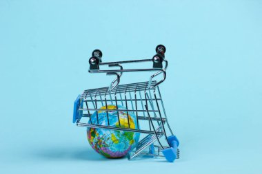 Küresel Alışveriş konsepti. Mavi stüdyo arka planında küresel market tramvayı. Minimalizm