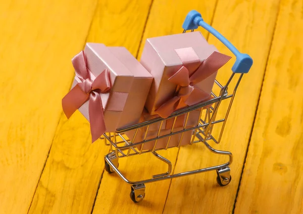 Shopping Vagn Och Presentförpackningar Med Rosetter Gul Trä Bakgrund — Stockfoto